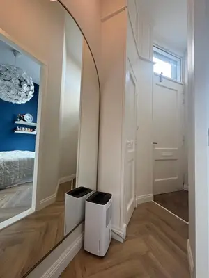 a hallway with a mirror and a bed in a room at Lovely small apartment in 'De Pijp' in Amsterdam