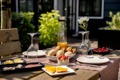 a table with food and wine glasses on it at Saenliefde in Wormer