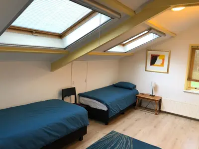two beds in a room with two skylights at Familiehuis Achter de Duijnhoeve Bakkum in Zuidbakkum