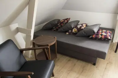 a couch with pillows and a table in a room at Miriam's Suite Amsterdam in Amsterdam
