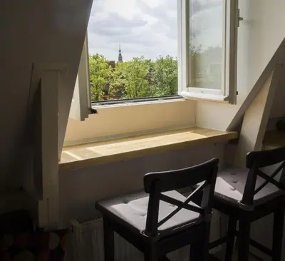 two chairs sitting next to a window with a view at Miriam's Suite Amsterdam in Amsterdam