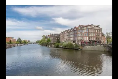 a river in a city with houses and buildings at Miriam's Suite Amsterdam in Amsterdam