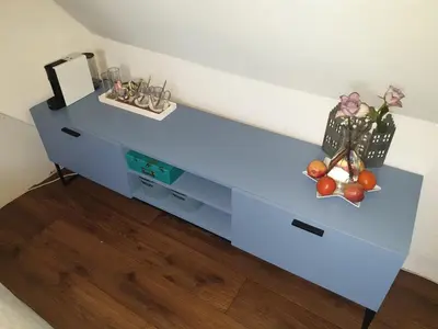 a blue dresser with a bowl of fruit on it at Bed & Bye Schiphol in Badhoevedorp