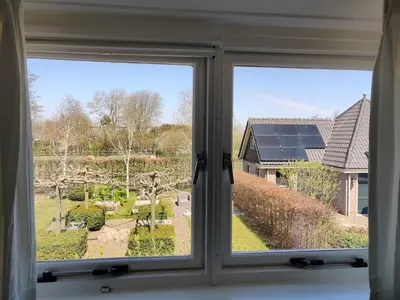 a window with a view of a garden seen through it at B&B Be Our Guest in Sint Maarten
