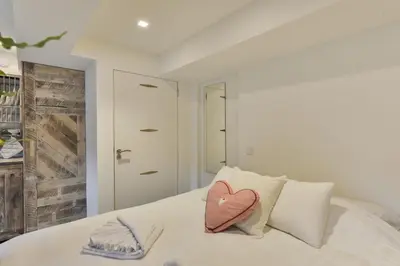 a white bed with a heart pillow on it at Luxury Beach Studio Zandvoort in Zandvoort