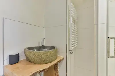 a bathroom with a stone sink on a wooden table at Luxury Beach Studio Zandvoort in Zandvoort