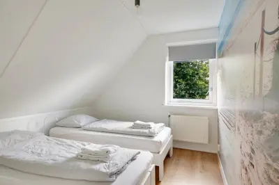 two beds in a small room with a window at Vakantiewoning Seaewald in Zeewolde