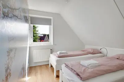 two beds in a small room with a window at Vakantiewoning Seaewald in Zeewolde