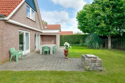 a patio with a table and chairs in a yard at Vakantiewoning Seaewald in Zeewolde