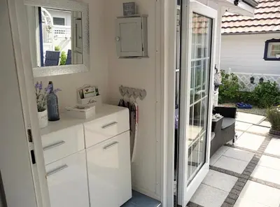 a kitchen with white cabinets and a sliding glass door at Ferienpark Vislust Haus De Graaf Niederlande Ijsselmeer in Wervershoof