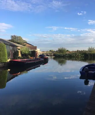 a river with boats parked on the side of it at Ferienpark Vislust Haus De Graaf Niederlande Ijsselmeer in Wervershoof
