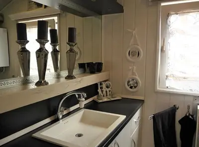 a kitchen with a sink and a window and a mirror at Ferienpark Vislust Haus De Graaf Niederlande Ijsselmeer in Wervershoof
