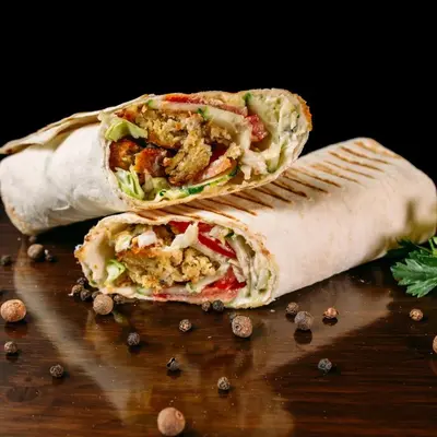 two halves of a burrito sitting on a table at Tamar in Katwijk aan Zee