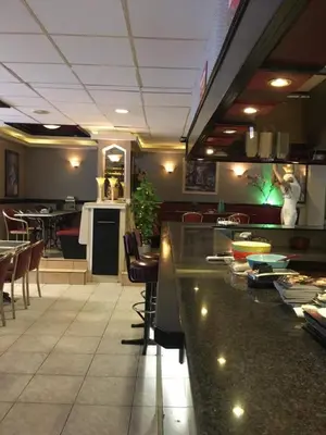 a restaurant with a bar with chairs and tables at Tamar in Katwijk aan Zee