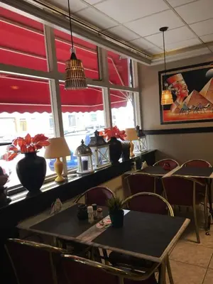 a dining room with a table and chairs and windows at Tamar in Katwijk aan Zee