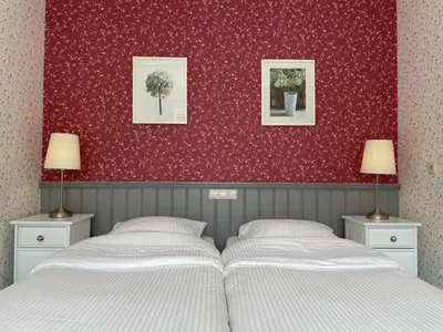 a bedroom with two beds and a red wall at Bed & Breakfast Pax Tibi in Reeuwijk