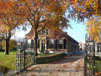a house with a gate in front of it at Bed & Breakfast Pax Tibi in Reeuwijk