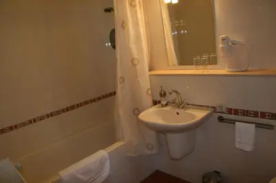 a bathroom with a sink and a mirror and a tub at Bed & Breakfast Pax Tibi in Reeuwijk