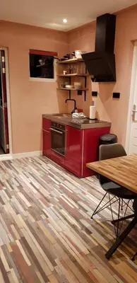 a kitchen with red cabinets and a wooden table at Jabaki Red Studio in Hoofddorp