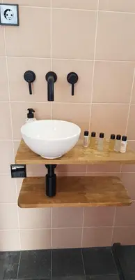 a white sink on a wooden shelf in a bathroom at Jabaki Red Studio in Hoofddorp
