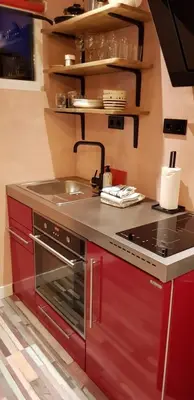 a kitchen with red cabinets and a sink at Jabaki Red Studio in Hoofddorp