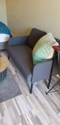 a couch with a pillow on it in a living room at JaBaKi Green Studio in Hoofddorp