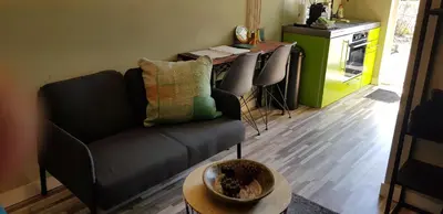 a living room with a couch and a table at JaBaKi Green Studio in Hoofddorp