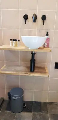 a bathroom with a bowl sink on a shelf at JaBaKi Green Studio in Hoofddorp