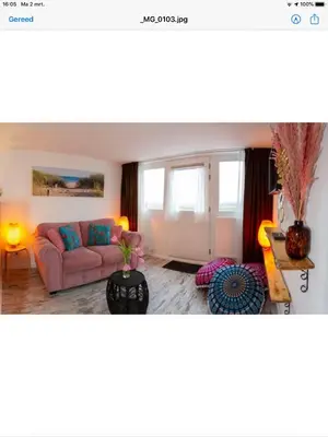 a living room with a pink couch and a table at little ibiza in Zandvoort