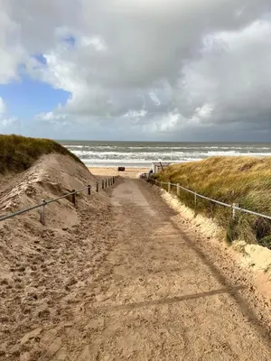 a dirt road leading to the ocean on a beach at Cosy Casa in Egmond aan Zee