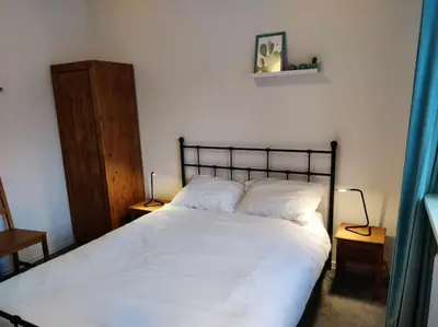 a bedroom with a large white bed with two lamps at In het Centrum in Bergen