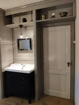 a bathroom with a sink and a mirror and a door at In het Centrum in Bergen