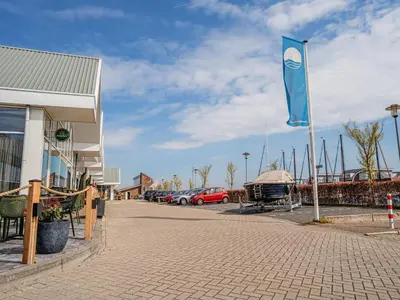 a blue flag on a pole in a parking lot at Harbour Lodge at Uitgeestermeer View in Uitgeest