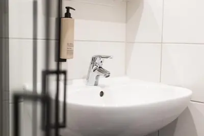 a white bathroom sink with a soap dispenser on it at Weber Hotel 117 in Amsterdam
