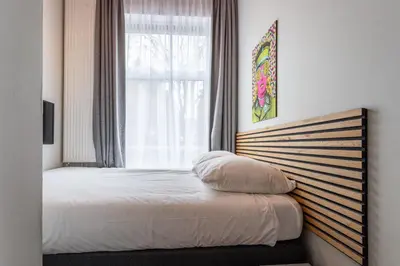 a bedroom with a bed with a window and a bed sidx sidx sidx at Weber Hotel 117 in Amsterdam