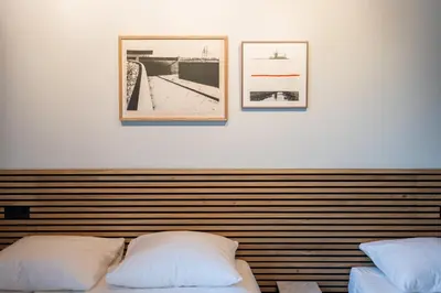 a bedroom with two beds and two pictures on the wall at Weber Hotel 117 in Amsterdam