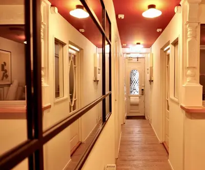 a corridor of a hallway with a door and a window at Weber Hotel 117 in Amsterdam