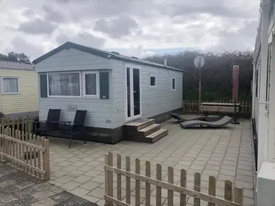 a tiny house on a patio with a fence at Luxe Chalet op camping Duindoorn, IJmuiden aan Zee, in de buurt van F1 circuit Zandvoort en Bloemendaal op loopafstand strand in IJmuiden