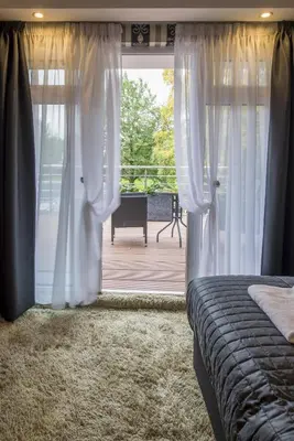 a bedroom with a bed and a sliding glass door at Villa Monte Dana in Zwanenburg