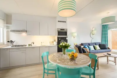 a kitchen and living room with a table and chairs at Center Parcs Zandvoort beach in Zandvoort
