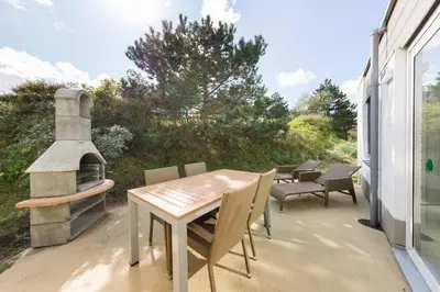 a patio with a table and chairs and a fireplace at Center Parcs Zandvoort beach in Zandvoort