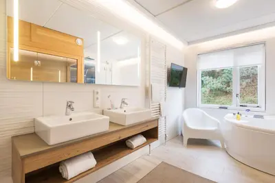 a bathroom with two sinks and a large mirror at Center Parcs Zandvoort beach in Zandvoort