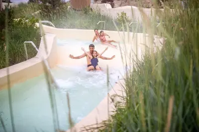 a group of people riding a slide in a pool at Center Parcs Zandvoort beach in Zandvoort