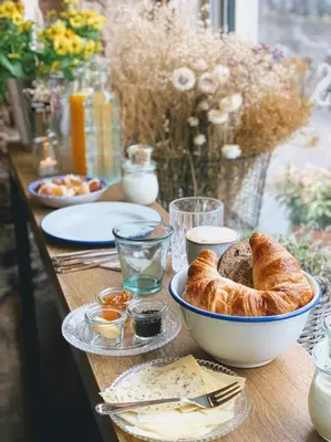 a table topped with a bowl of bread and other foods at Logement Petit Beijers in Utrecht