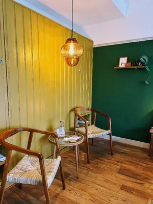 a room with two chairs and a table and a green wall at Logement Petit Beijers in Utrecht