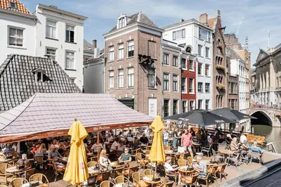 a group of people sitting at tables with umbrellas at Logement Petit Beijers in Utrecht