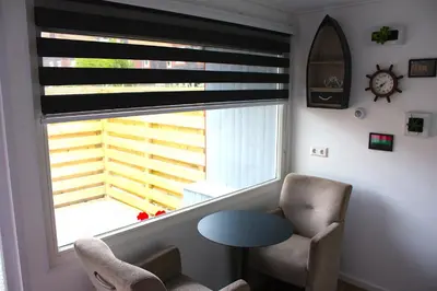 a room with a window with a chair and a table at Bed & Breakfast Aalsmeer in Aalsmeer