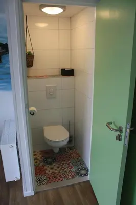 a bathroom with a toilet in a room at Bed & Breakfast Aalsmeer in Aalsmeer