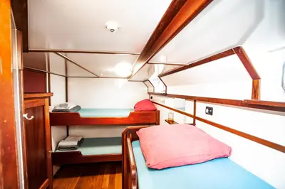 a small room with two beds in a boat at Amsterdam Hotelboat in Amsterdam