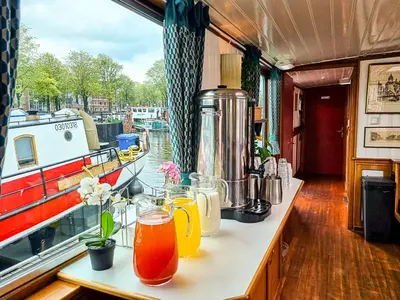 a table on a boat with drinks on it at Amsterdam Hotelboat in Amsterdam